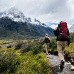 Two hikers approach a misty mountain