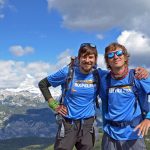 Domen Bancic poses with his arm around fellow guide Luka Furjan, with mountains in the background