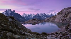 small cabin on Mont Blanc lake with picturesque snowcapped mountain backdrop