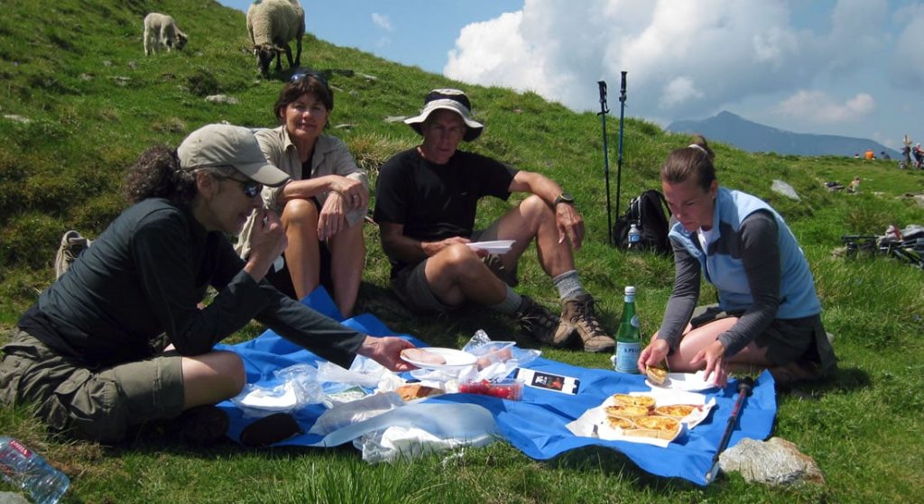 Hikers stop for a picnic on a grassy slope