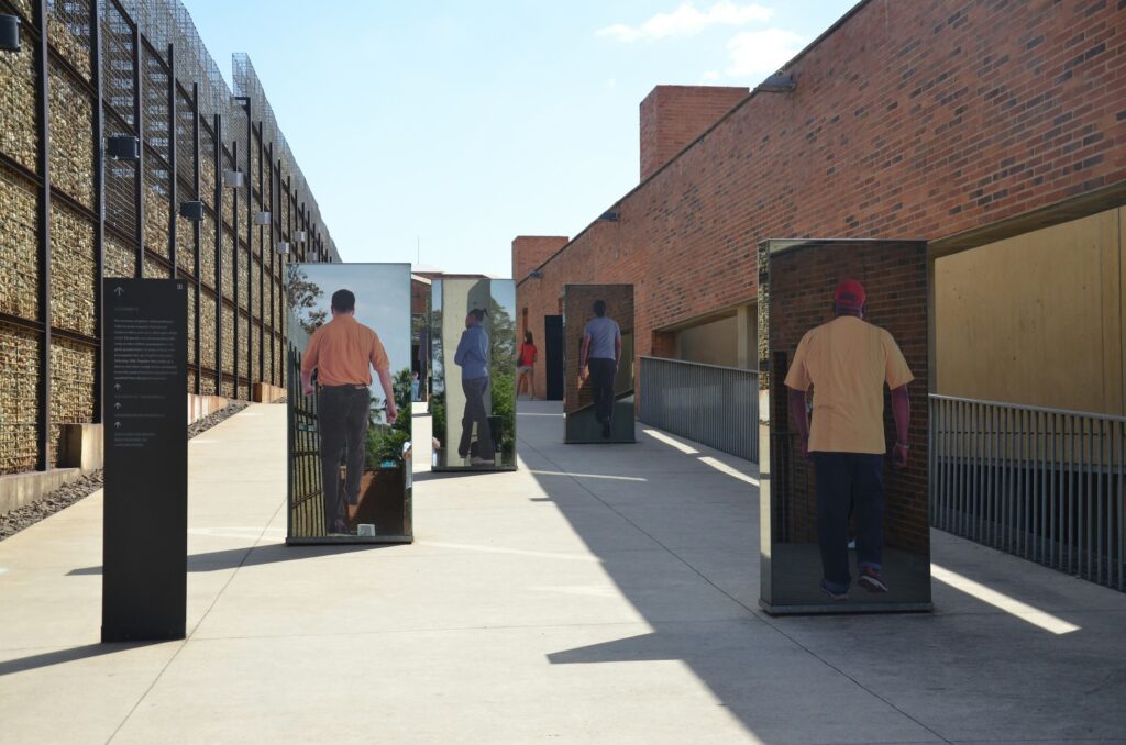 Johannesburg Apartheid Museum shows images of people printed on slabs, their backs to the camera