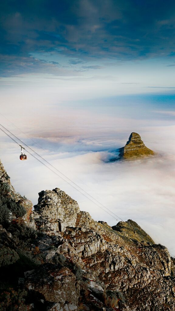 A cable car ascends a misty mountain