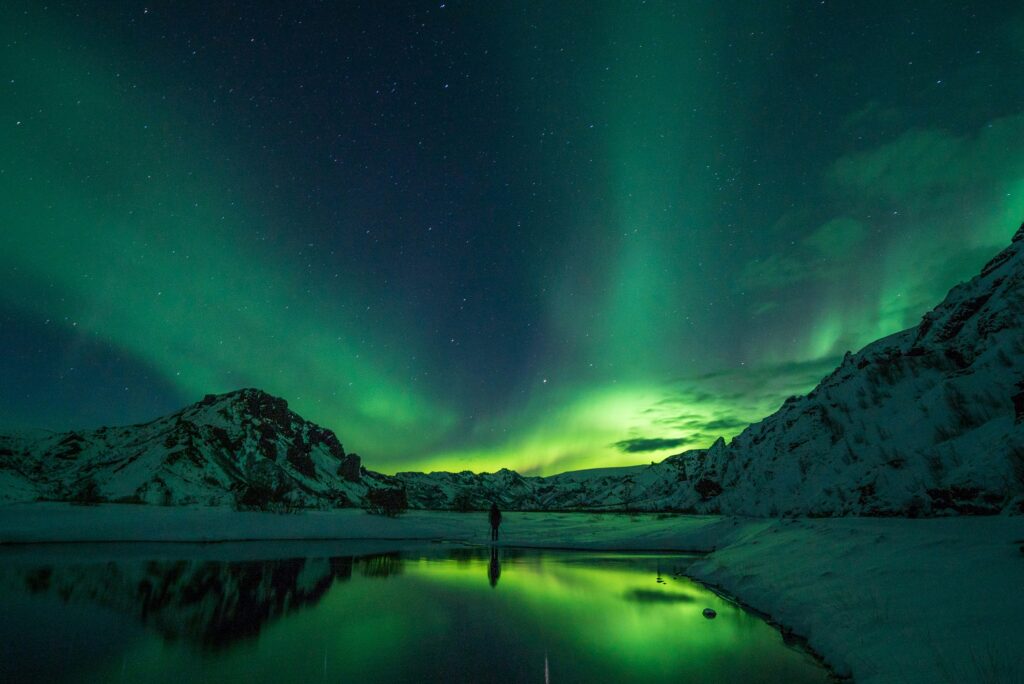 Green Aurora Borealis lights over frosty Icelandic landscape